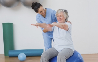 Instructor assisting senior woman during physical therapy